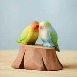 Bumbu wooden blue and lovebird figures perched on a Bumbu wooden stump