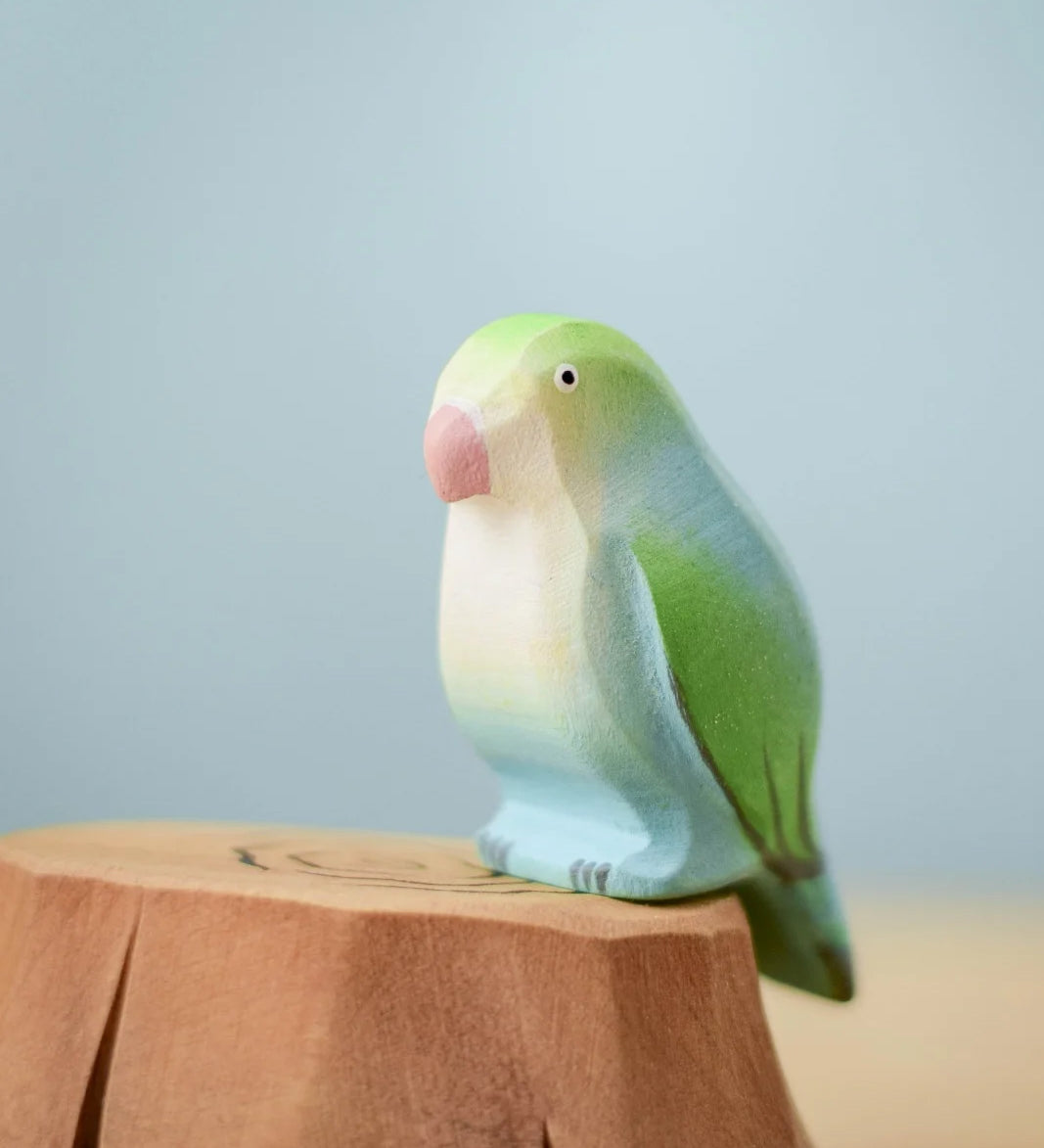 Bumbu wooden blue lovebird figure perched on a Bumbu wooden stump