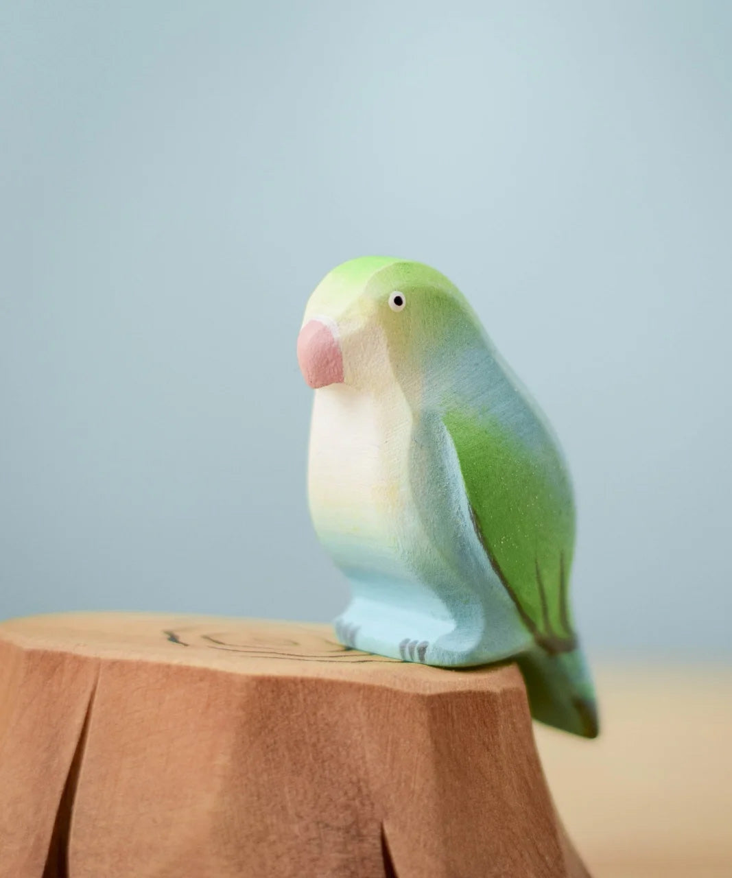 Bumbu wooden blue lovebird figure perched on a Bumbu wooden stump