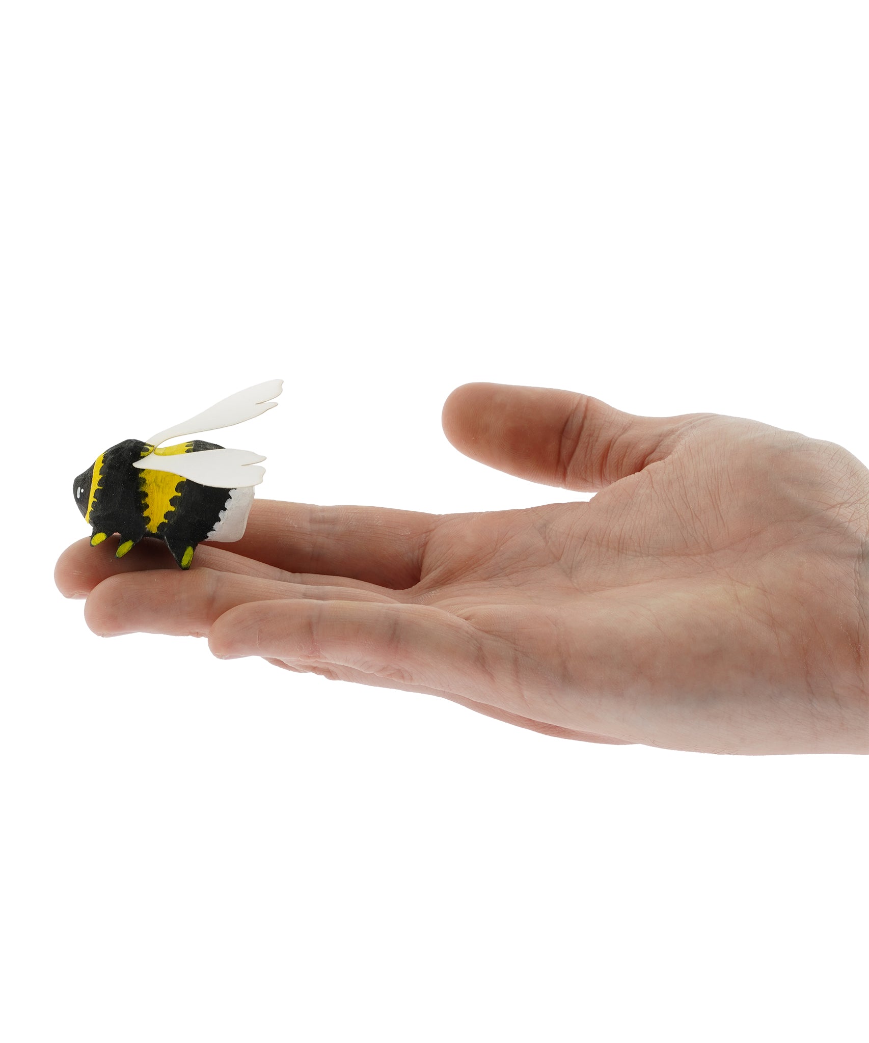 The Bumbu Wooden Bumblebee Figure pictured on an adult's hand