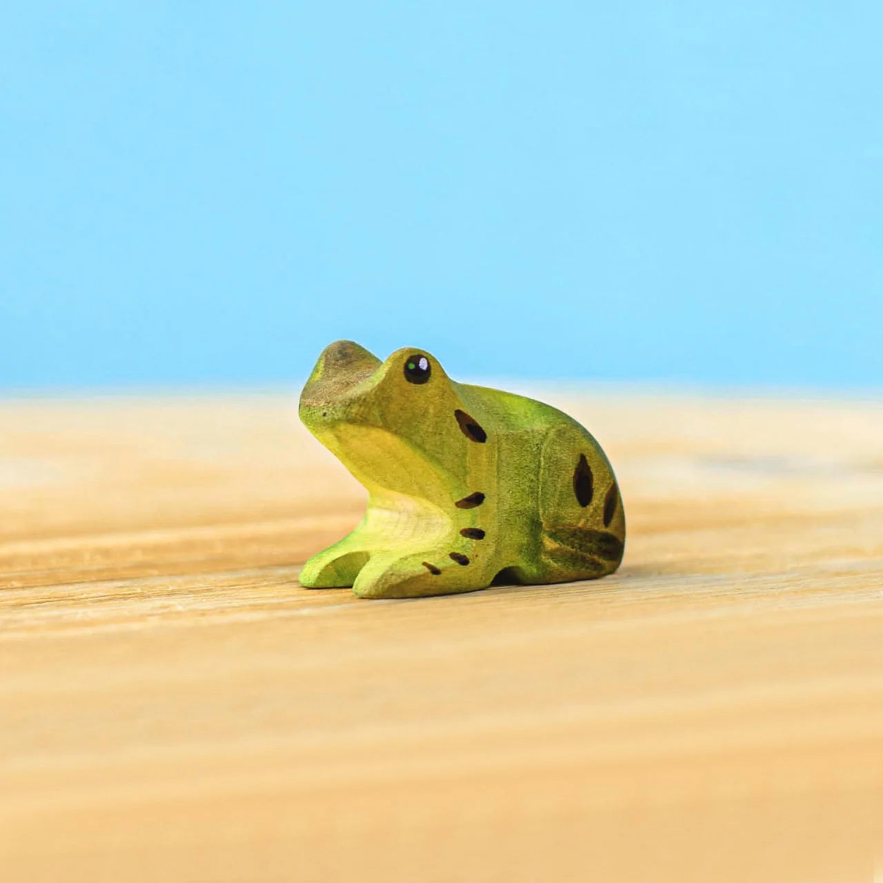 Diagonal view of the Bumbu green wooden frog. 