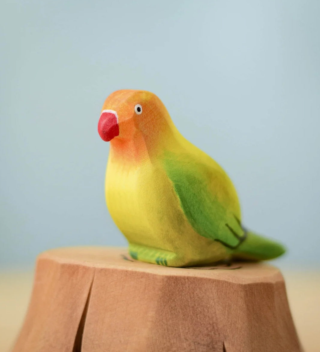 Bumbu wooden green lovebird figure perched on a Bumbu wooden stump