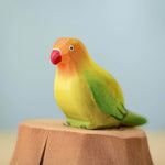 Bumbu wooden green lovebird figure perched on a Bumbu wooden stump