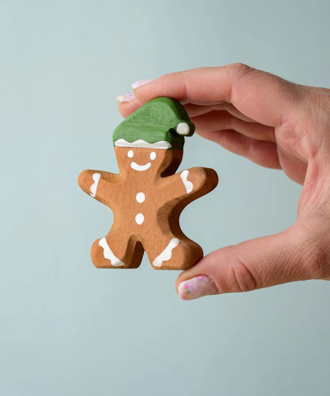 A hand holding the Bumbu gingerbread cookie boy