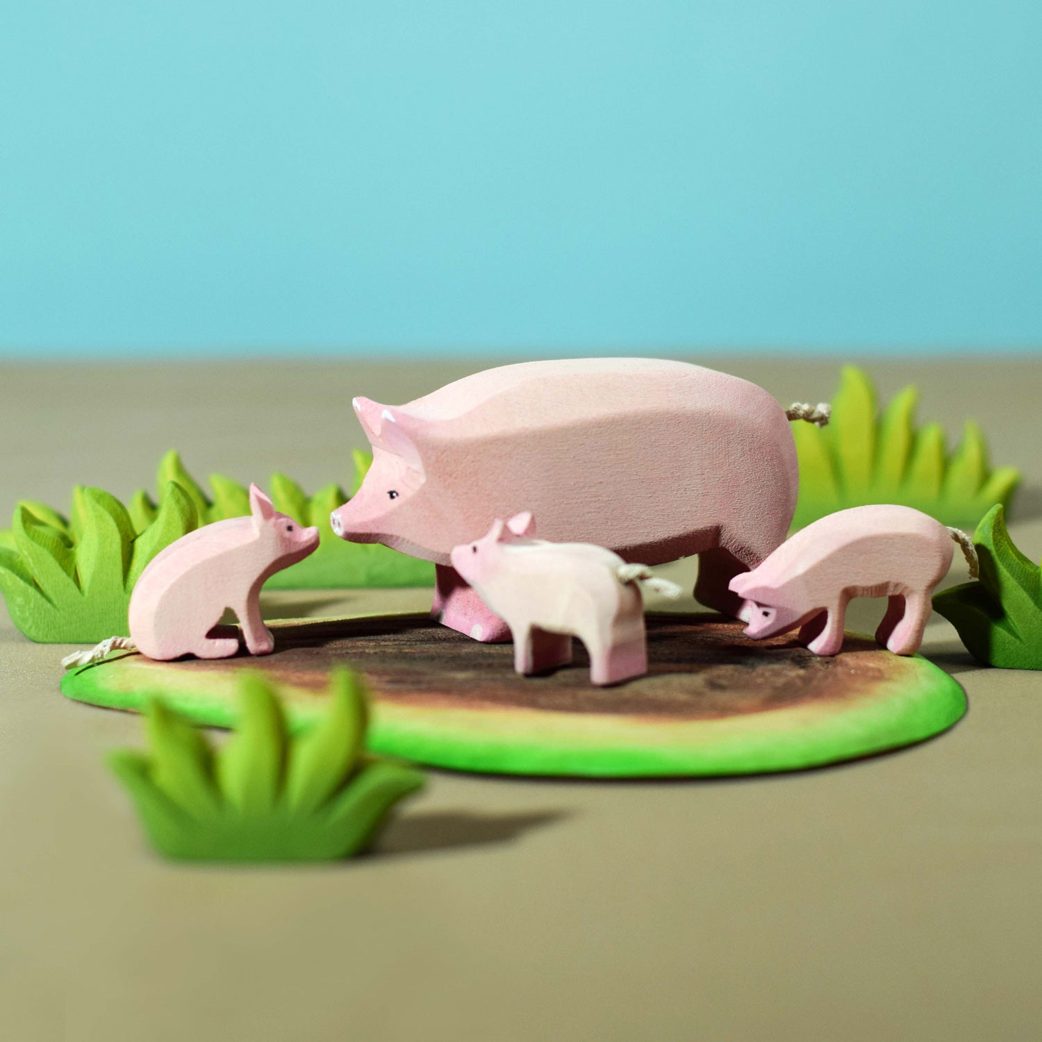 Bumbu wooden pig family on a wooden mud base surrounded by wooden grass