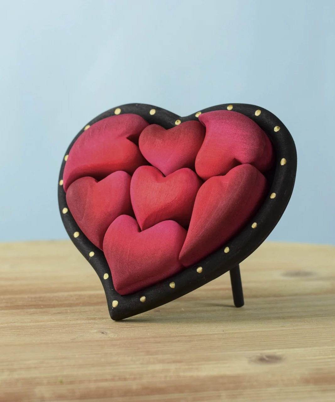 Bumbu wooden red hearts puzzle set in a wooden heart frame standing on a table