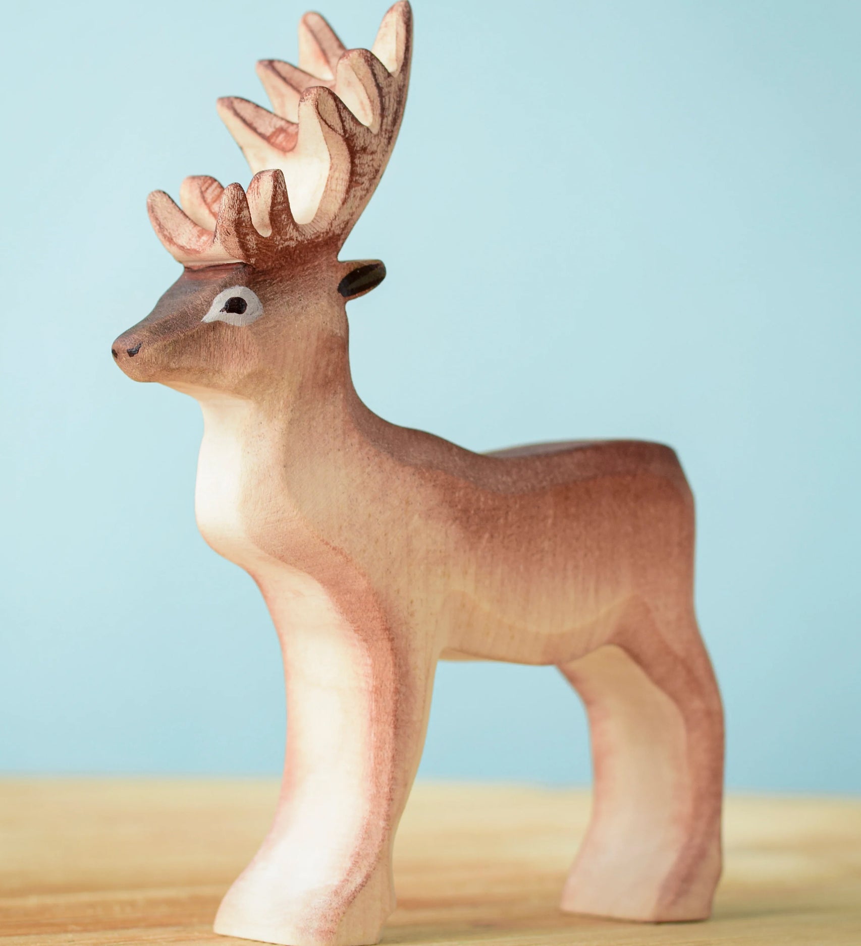 Bumbu Toys Reindeer figure placed on a wooden surface. 