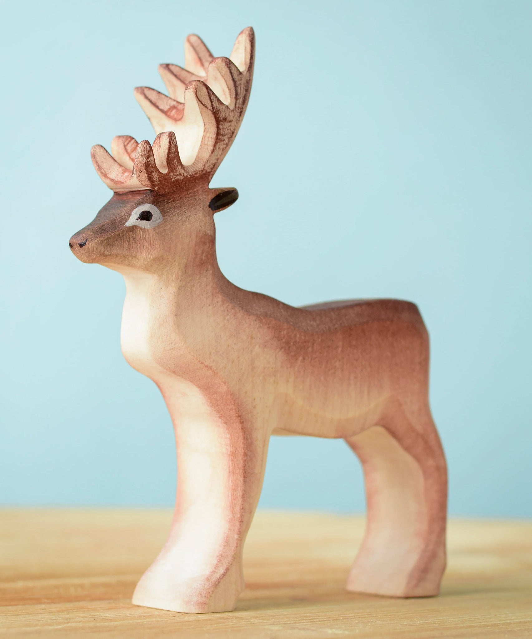 Bumbu Toys Reindeer figure placed on a wooden surface. 