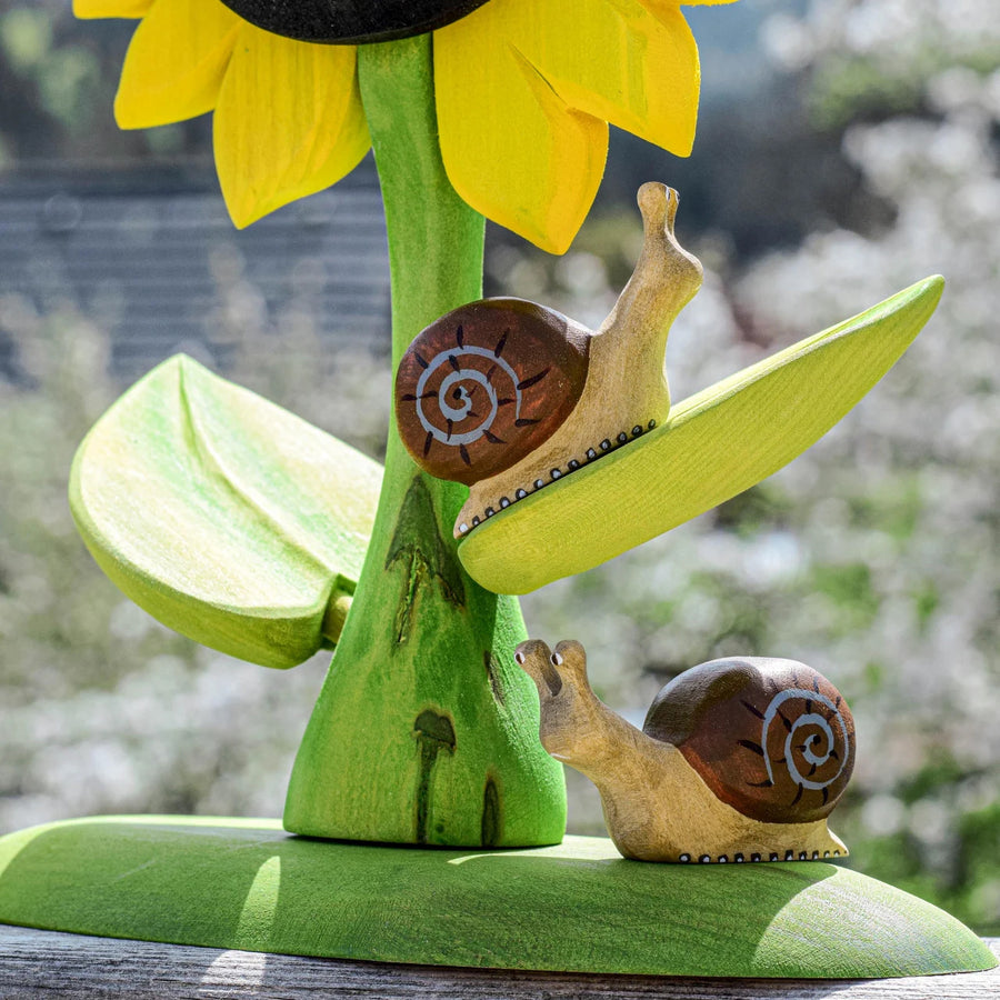  on a green wooden base next to a hand. On a blue background