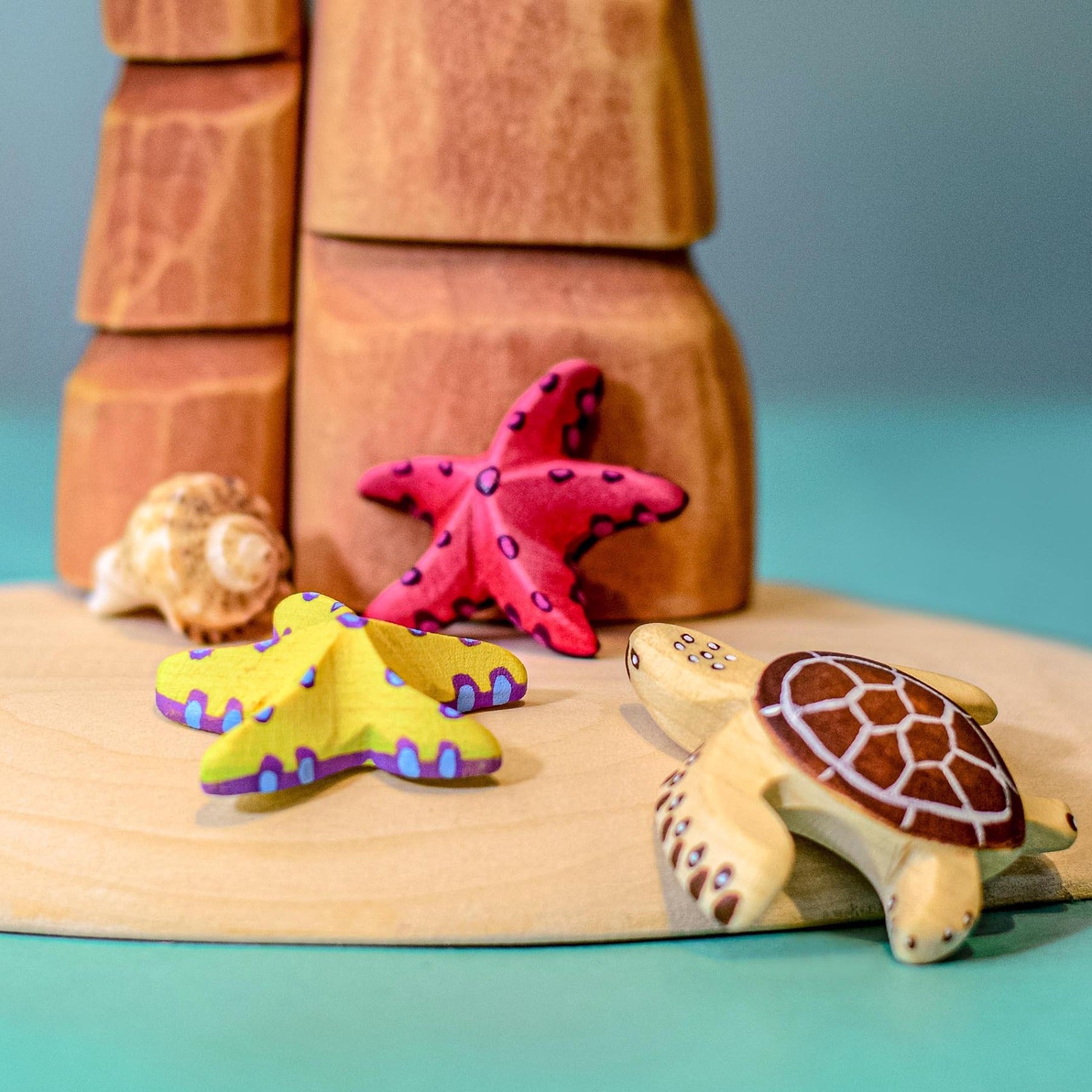 Bumbu Wooden Red Starfish Set posed in a beach scene.