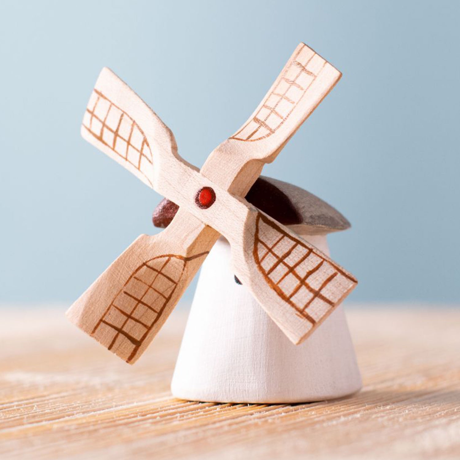 Bumbu Miniature Wooden Moldova Windmill. The toy sits on a wooden surface against a blue background.