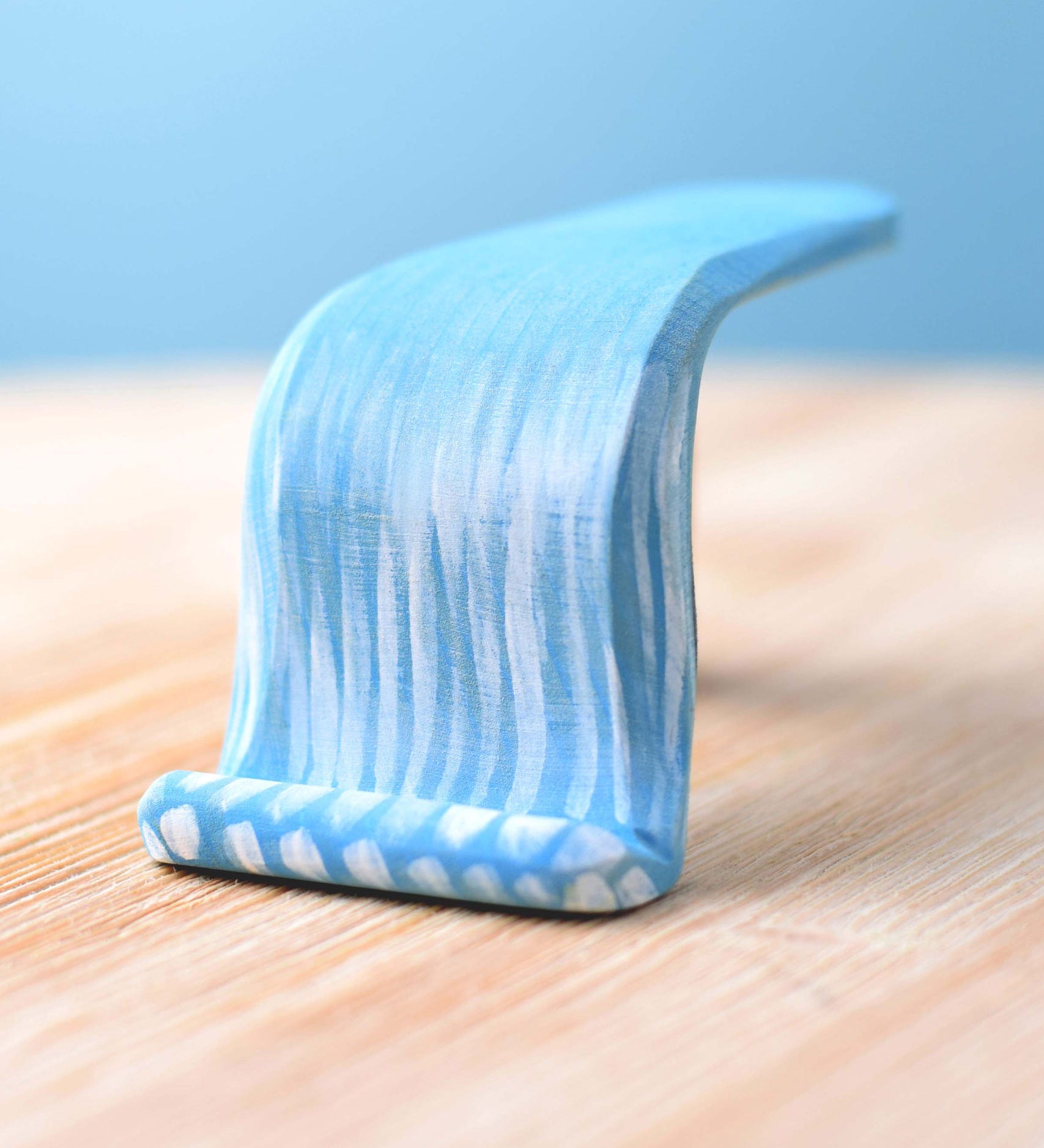 Bumbu Wooden Waterfall. The toy sits on a wooden surface against a blue background.