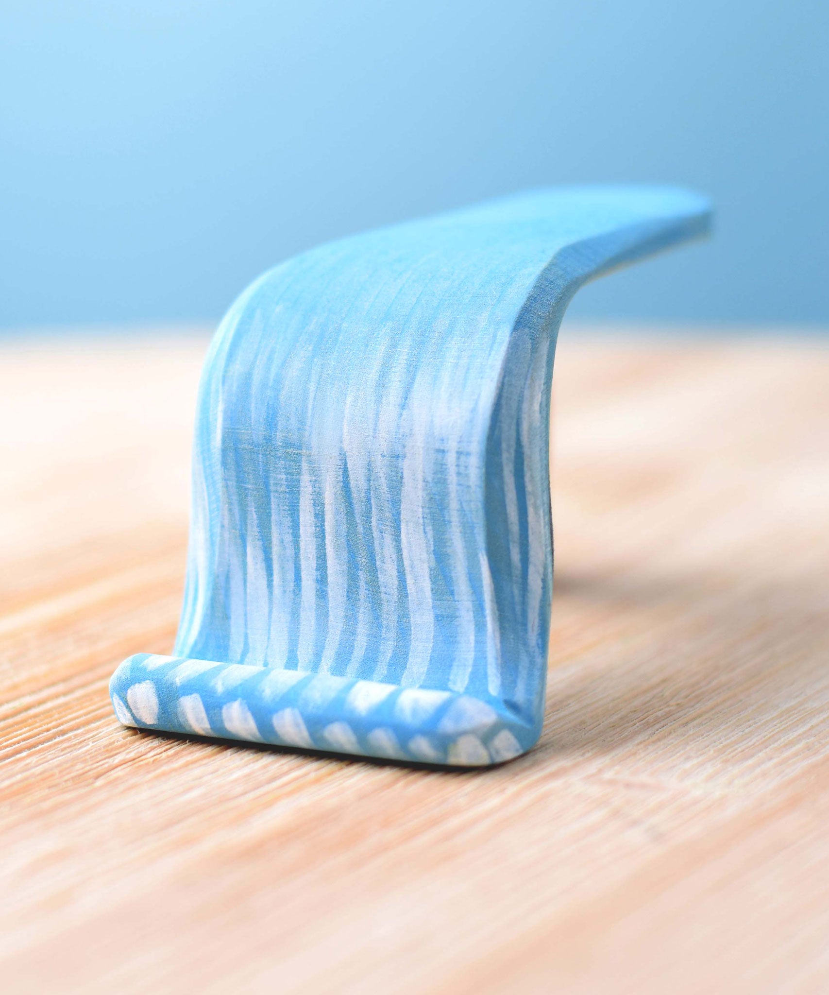 Bumbu Wooden Waterfall. The toy sits on a wooden surface against a blue background.