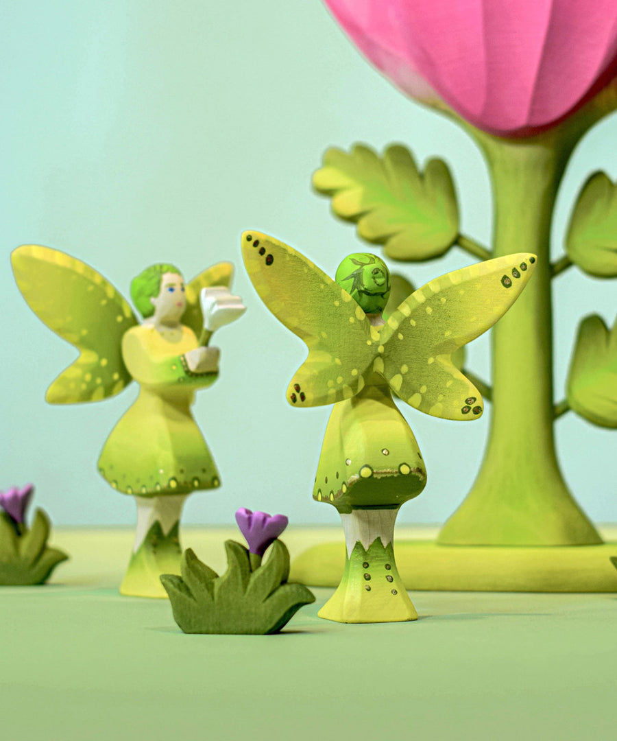 Two Bumbu woodland fairies standing facing each other. The back of one is shown in the image showing the detail on their wings and hair.