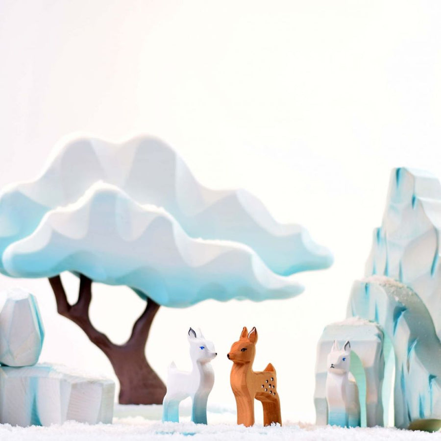 The Bumbu Icy Cliffs is a set of 5 handmade wooden blocks that stack together to make an icy mountain scene. With a family of wooden penguins arranged on the cliffs.