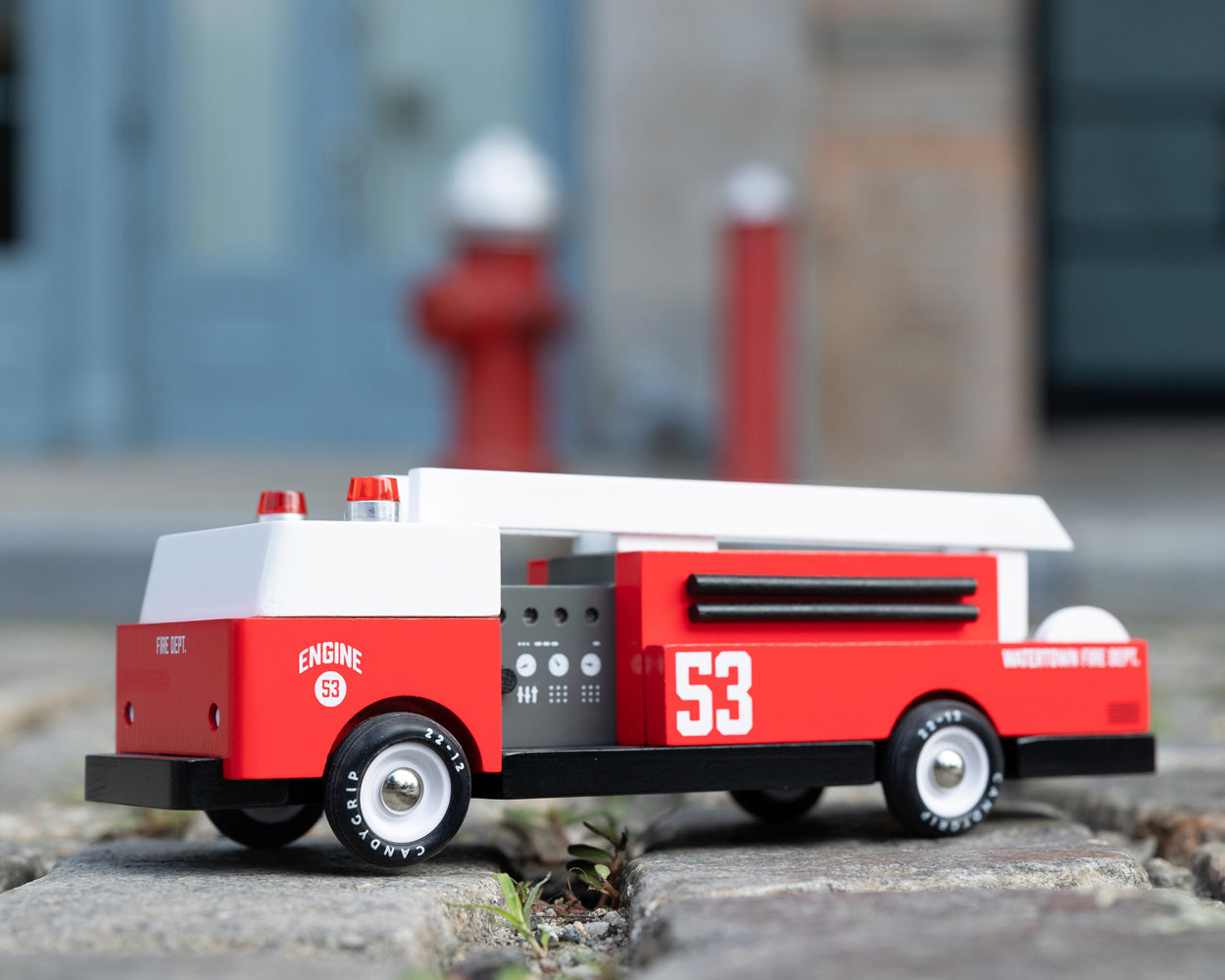 A Candylab Big Red Fire Engine pictured outdoors on a cobbled floor