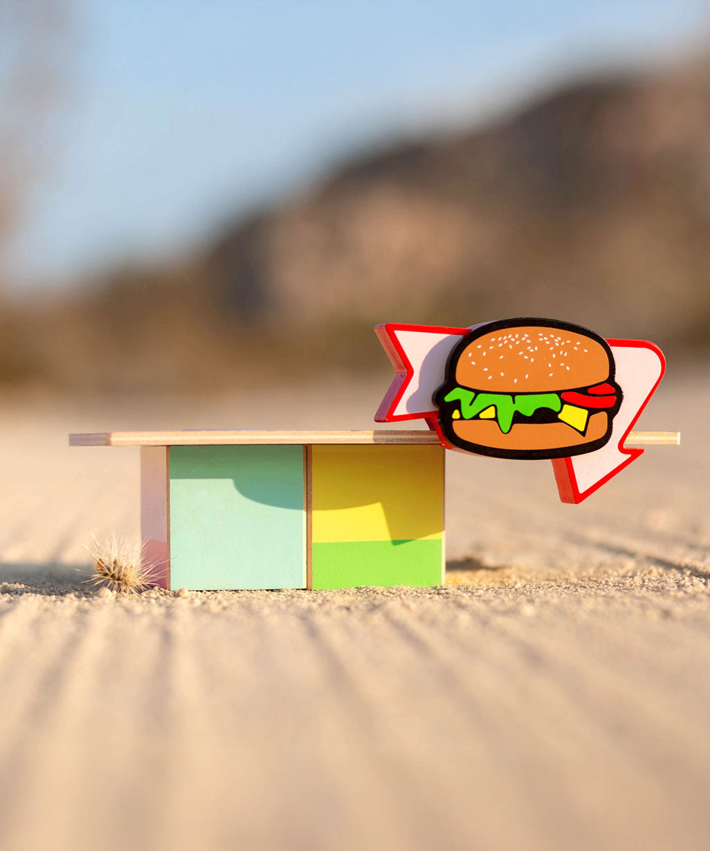 Candylab Burger Food Roadside Shack on a sandy surface outdoors.  