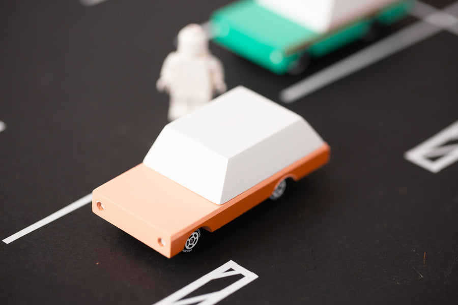 Close up of the candylab solid wooden brown car toy on a black rubber road