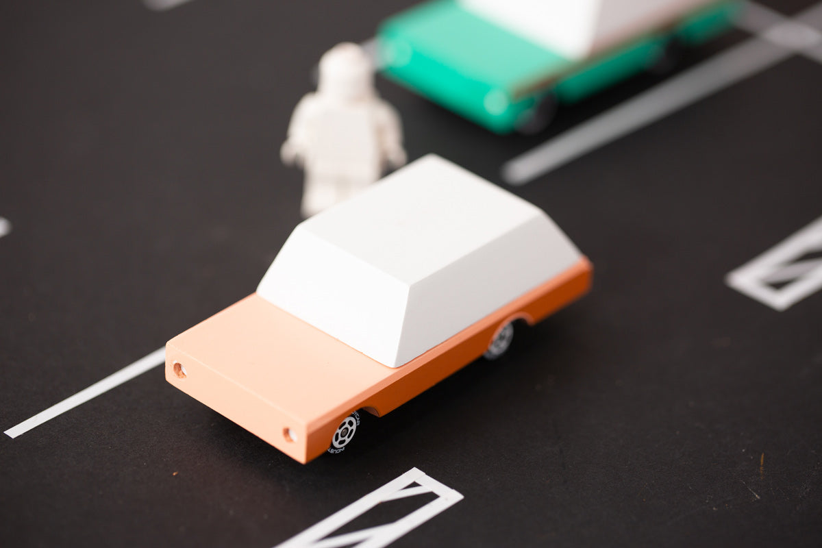 Close up of the candylab solid wooden brown car toy on a black rubber road