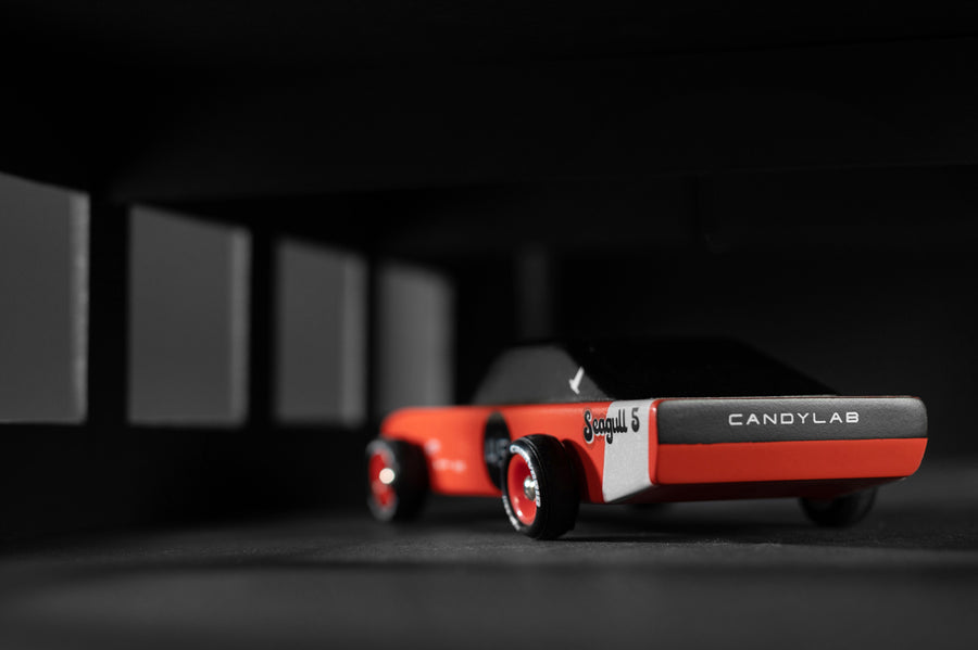 Close up of the back of the Candylab wooden seagull racing car toy on a black and grey background