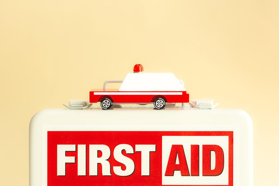 Candylab eco-friendly wooden ambulance car toy on top of a white first aid box