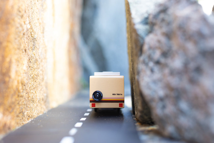 Close up of the Candylab childrens rv vehicle toy driving on a rubber road between two large rocks