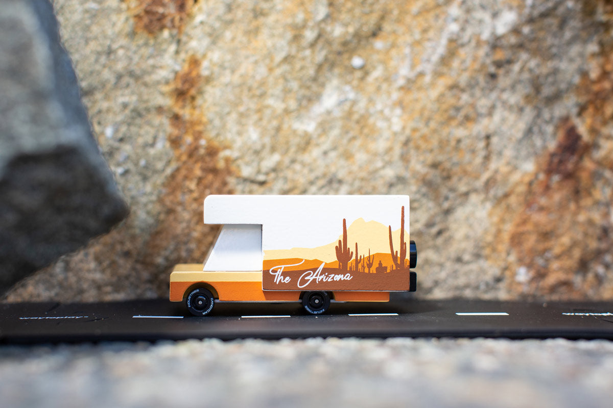 Side of the Candylab collectable campervan diecast toy in front of a large stone background