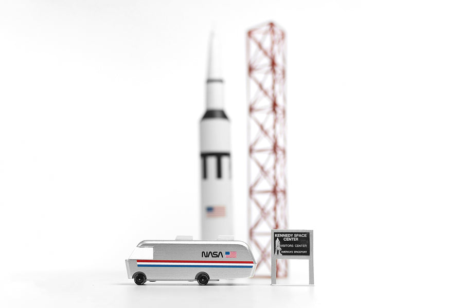 Candylab NASA astro van toy on a white background next to a miniature rocket ship