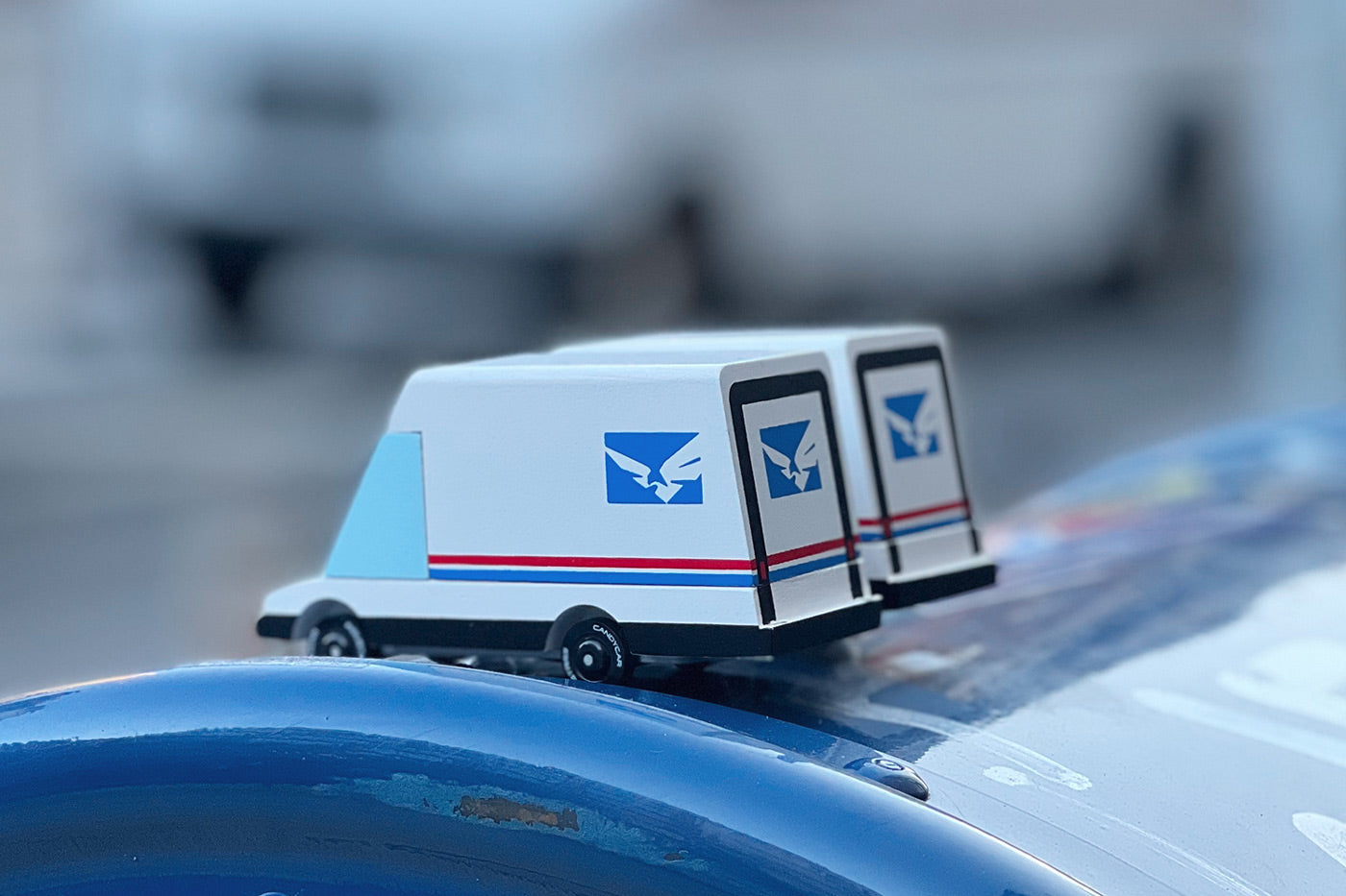 2 Candylab collectable miniature post van toys on a blue postbox