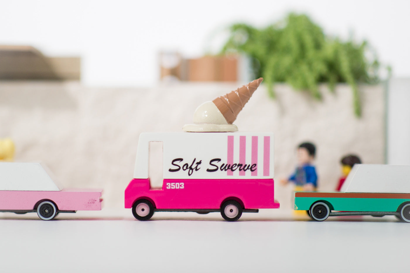 3 Candylab wooden car toys lined up on a white background with the ice cream van toy in the middle