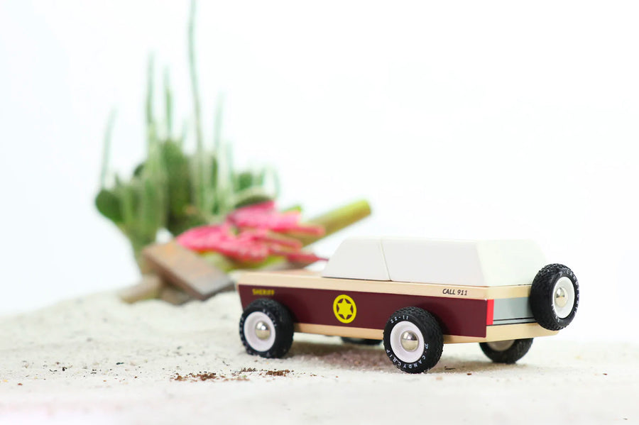 a vintage sheriffs car with burgundy stripe and yellow sherifs star