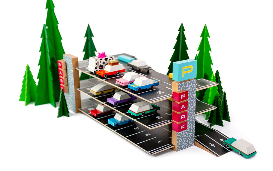 Candylab eco-friendly childrens vehicle parking garage toy on a white background next to some green toy trees