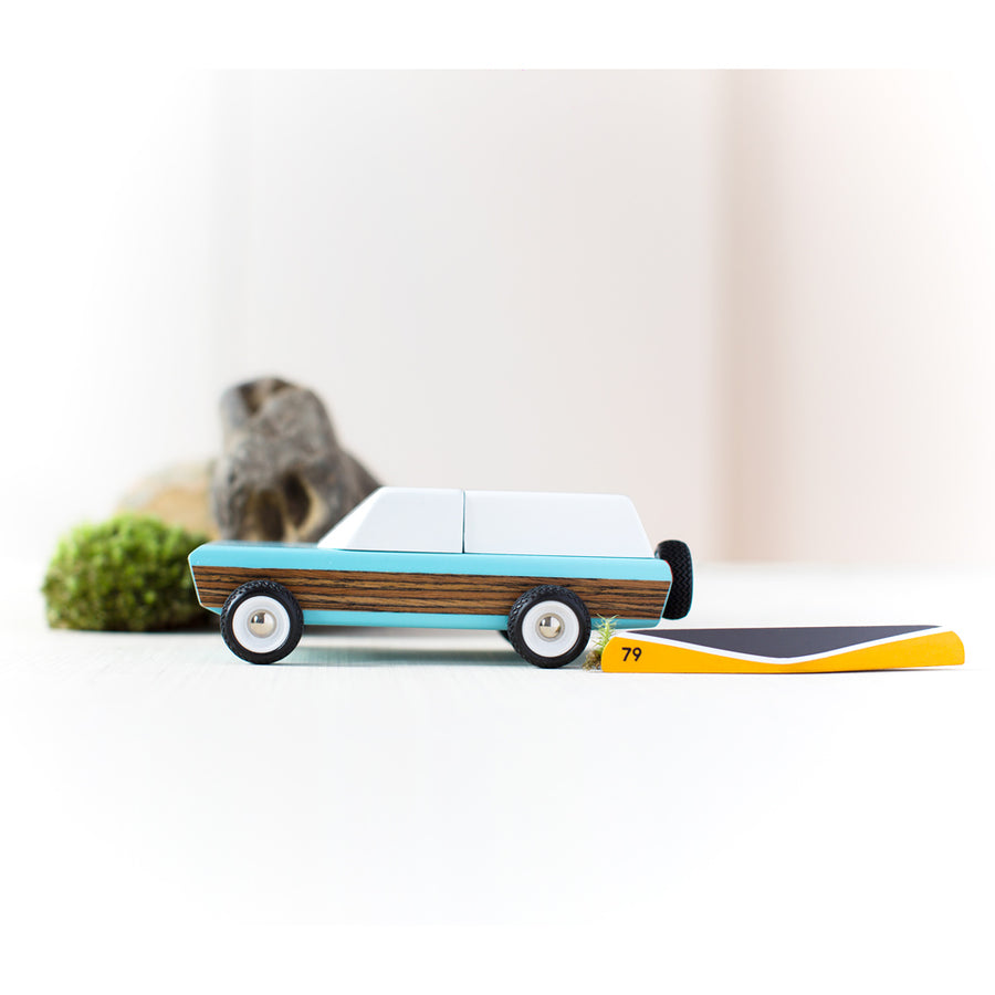 Candylab wooden pioneer classic car toy on a white background next to a miniature kayak toy