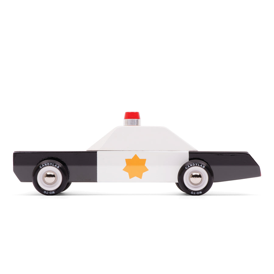 Side view of the Candylab handmade wooden police cruiser toy car on a white background