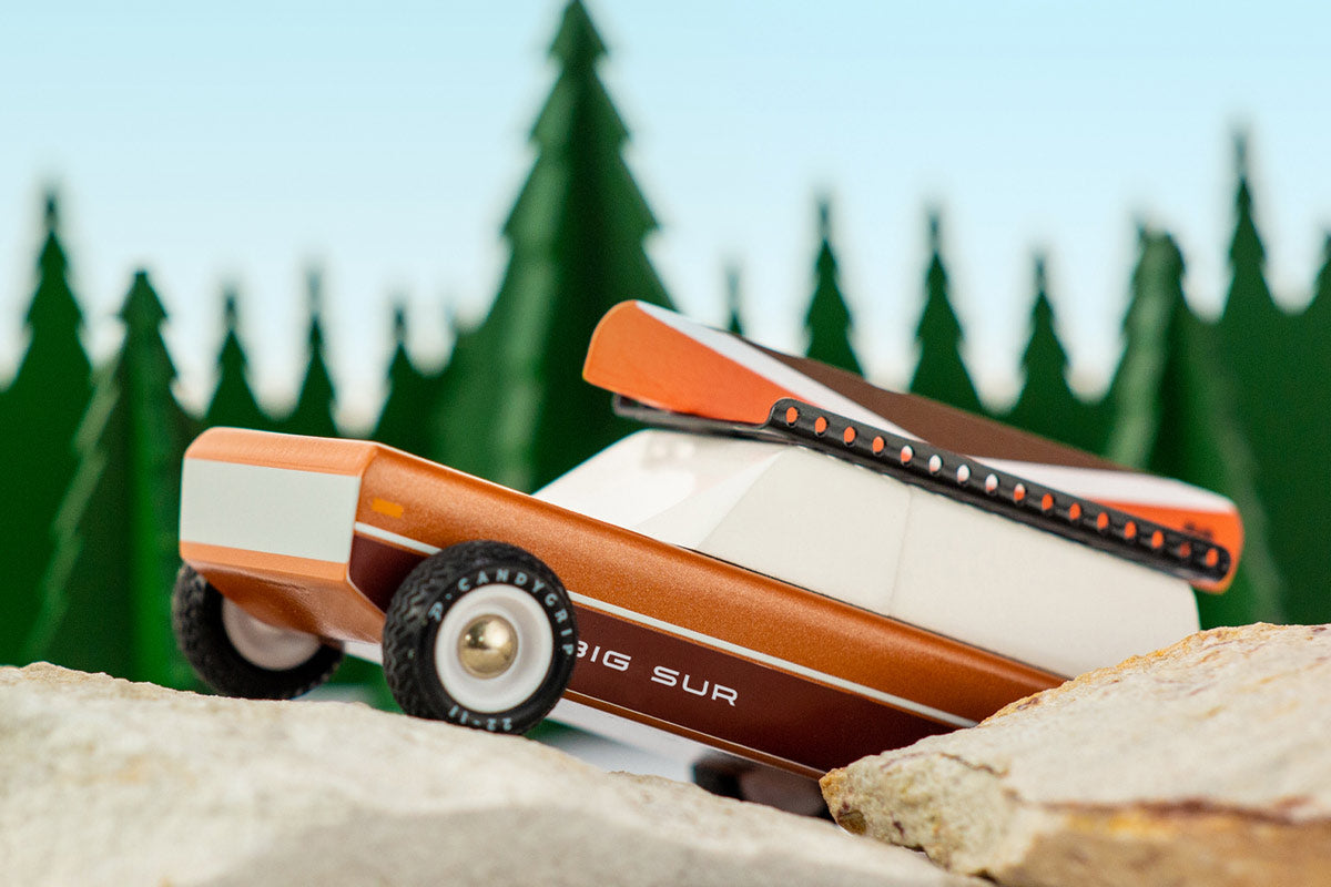 Close up of the Candylab eco-friendly wooden big sur car toy on some large rocks