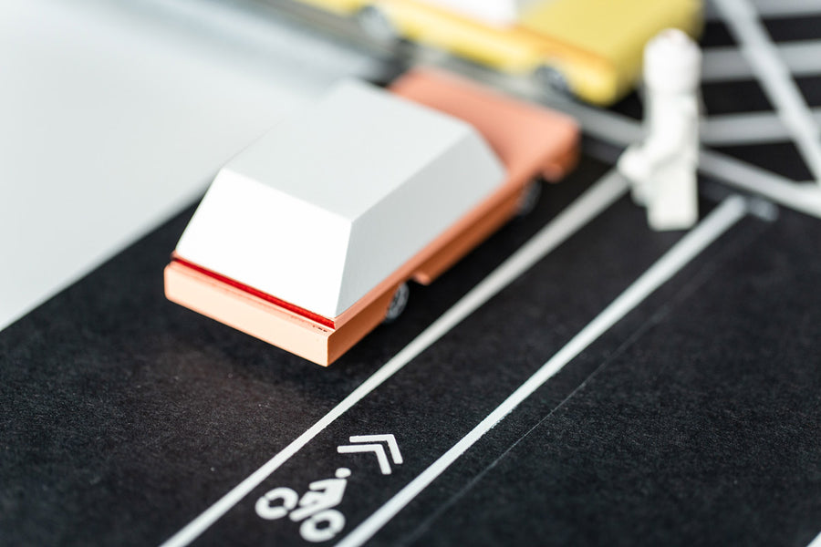 Close up of the back of a Candylab wooden dart toy car on a rubber road