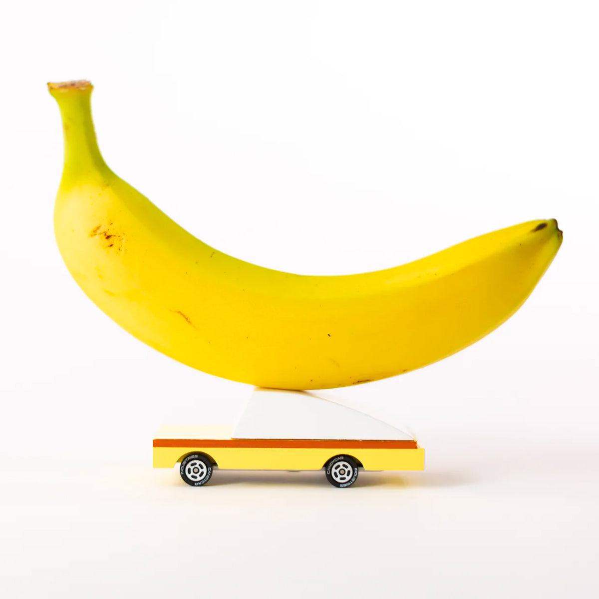 Candylab kids yellow toy car on a white background with a banana on its roof