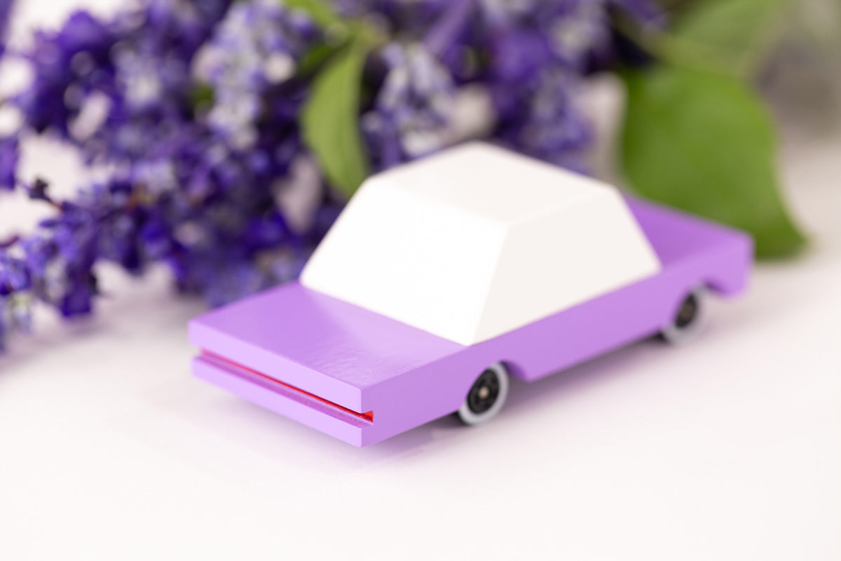 Candylab childrens wooden bberry candycar on a white background next to some purple flowers