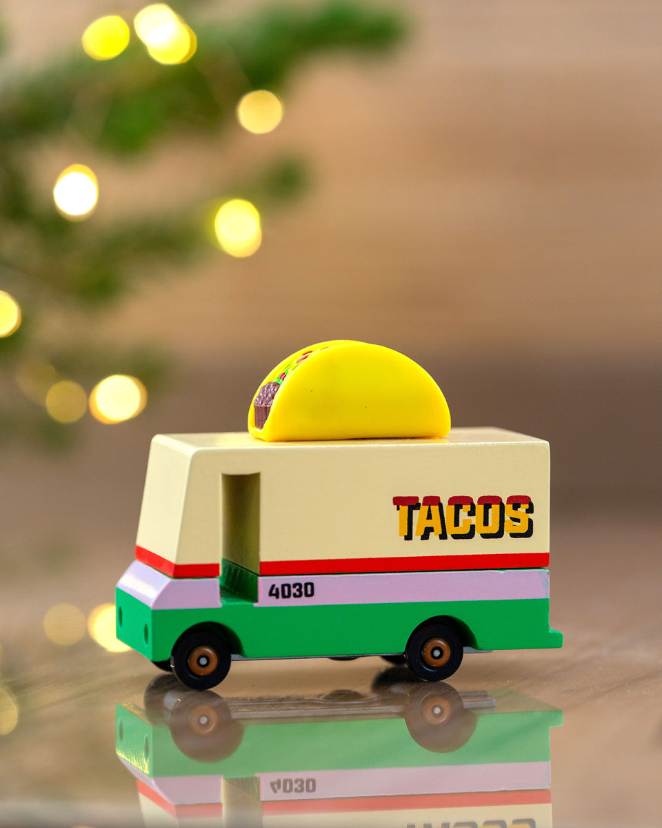 Close up of the Candylab wooden taco van toy truck in front of some Christmas lights