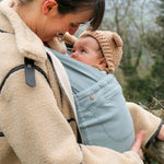 Close up of woman looking at her baby in the close caboo organic baby carrier in the sage colour