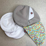 Close maternity breast feeding pads on a grey floor next to the Close pastel print pad pouch