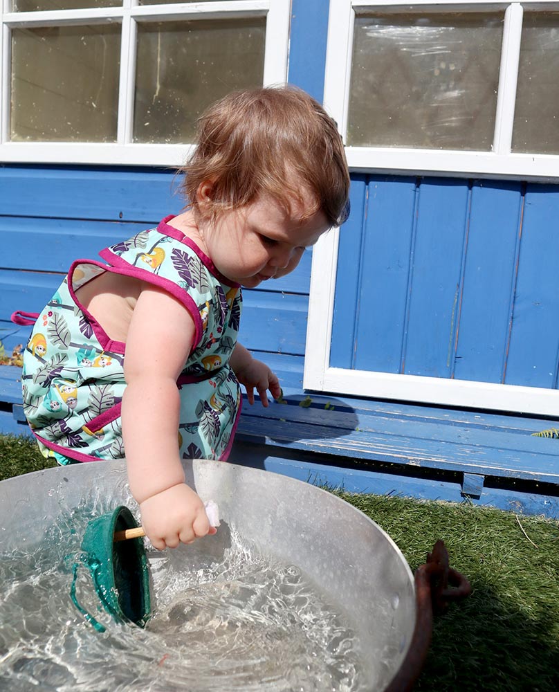 Close popin sloth sleeveless bib modelled by toddler