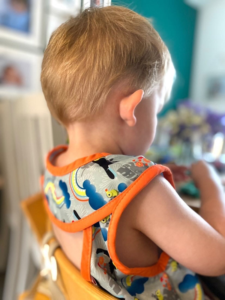 Close popin toucan sleeveless bib modelled by toddler