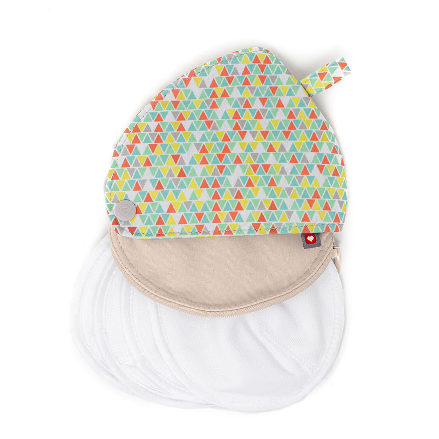 Close reusable breast pad pouch with 4 white breastfeeding pads falling out on a white background