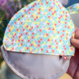 Close up of hand holding the Close pastels breast pad pouch