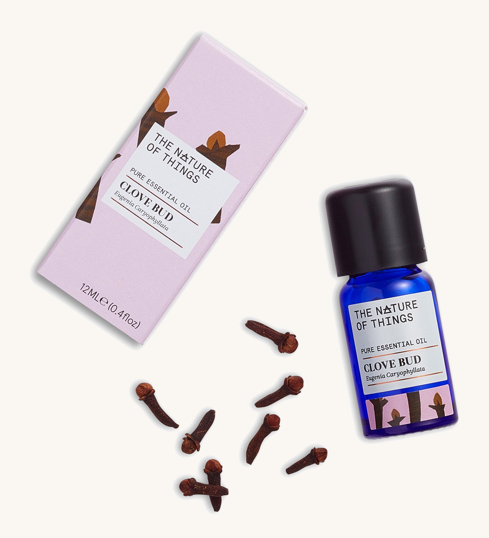 Organic Clove Bud pure essential oil in a blue glass bottle next to a decorative pink cardboard box, with cloves.