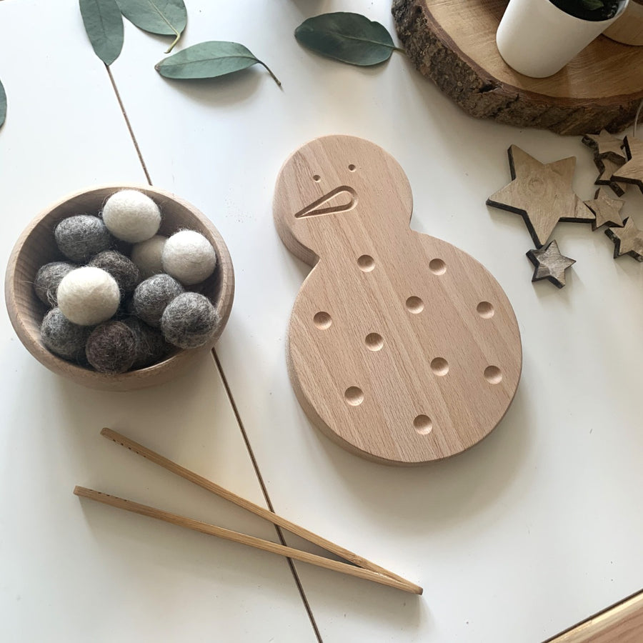 The Coach House Snowman Fine Motor Board in an invitation to play with a bowl filled white and grey pompoms