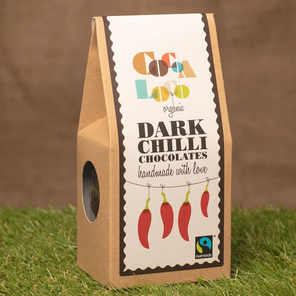 Box of Cocoa Loco Fairtrade dark chocolate chillies on some grass in front of a brown background