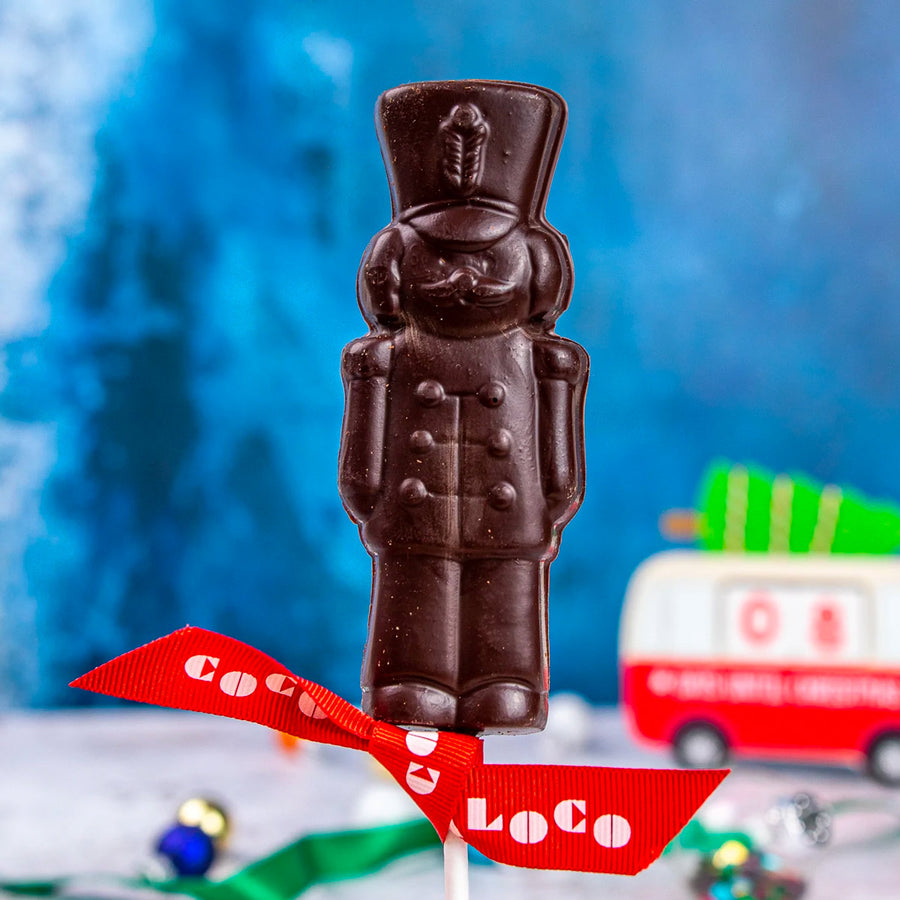 Close up of the Cocoa loco fairtrade dark chocolate soldier lolly on a blue blurred background