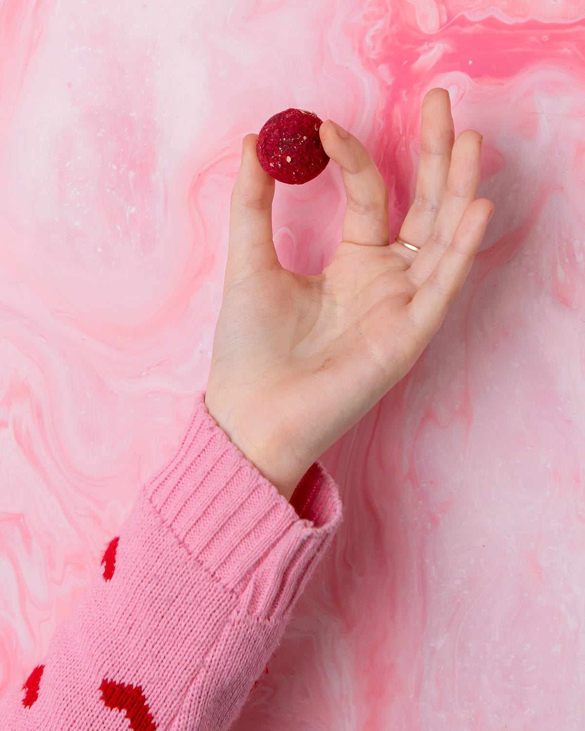 A person holding a Cocoa Loco Gin Truffle between their fingers